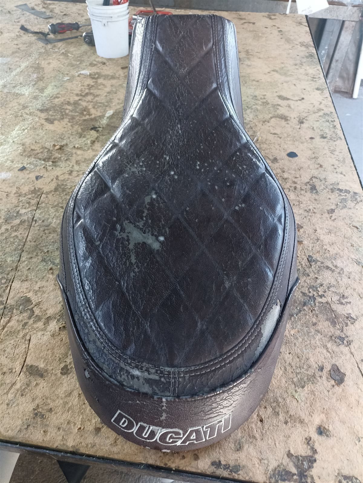 Worn Ducati motorcycle seat before restoration